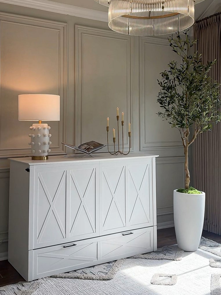 Key West white cabinet bed with decorative elements in a room with neutral walls and a plant.