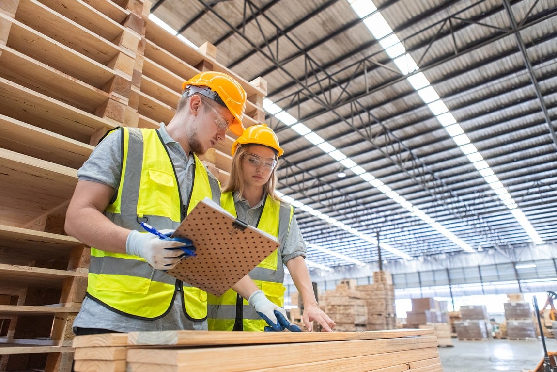 Two workers in a warehouse conducting product testing