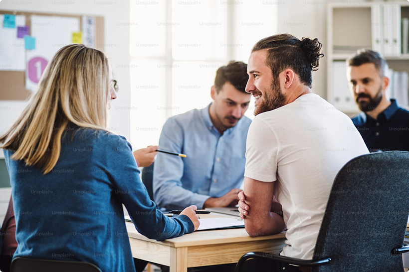 Group of people sitting around a table in an office setting
