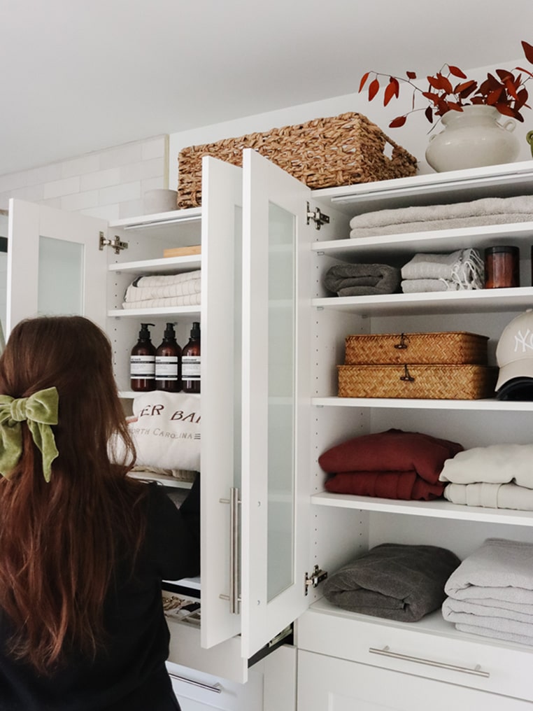 Person looking into a well-organized Florence collection wardrobe with folded clothes and baskets.