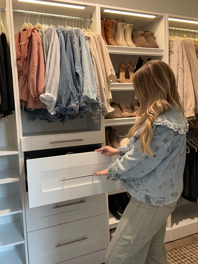 Woman opening a drawer in a well-organized Florence collection closet with clothes and shoes.