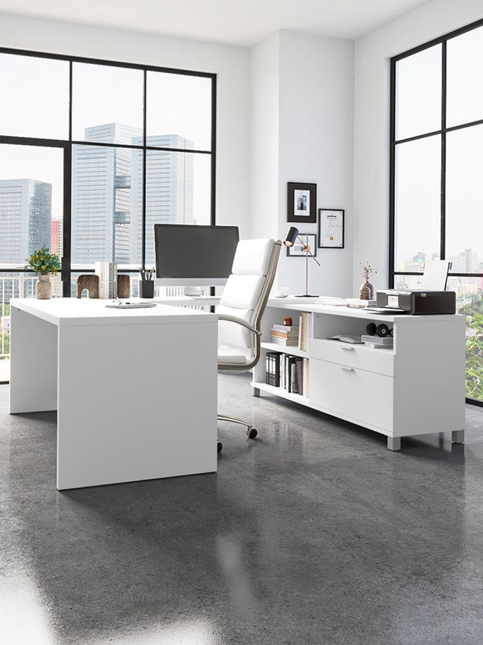 Modern office space with a large white desk, chairs, and office supplies.