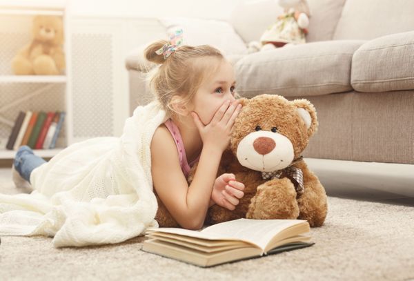 Girl with book and teddy bear