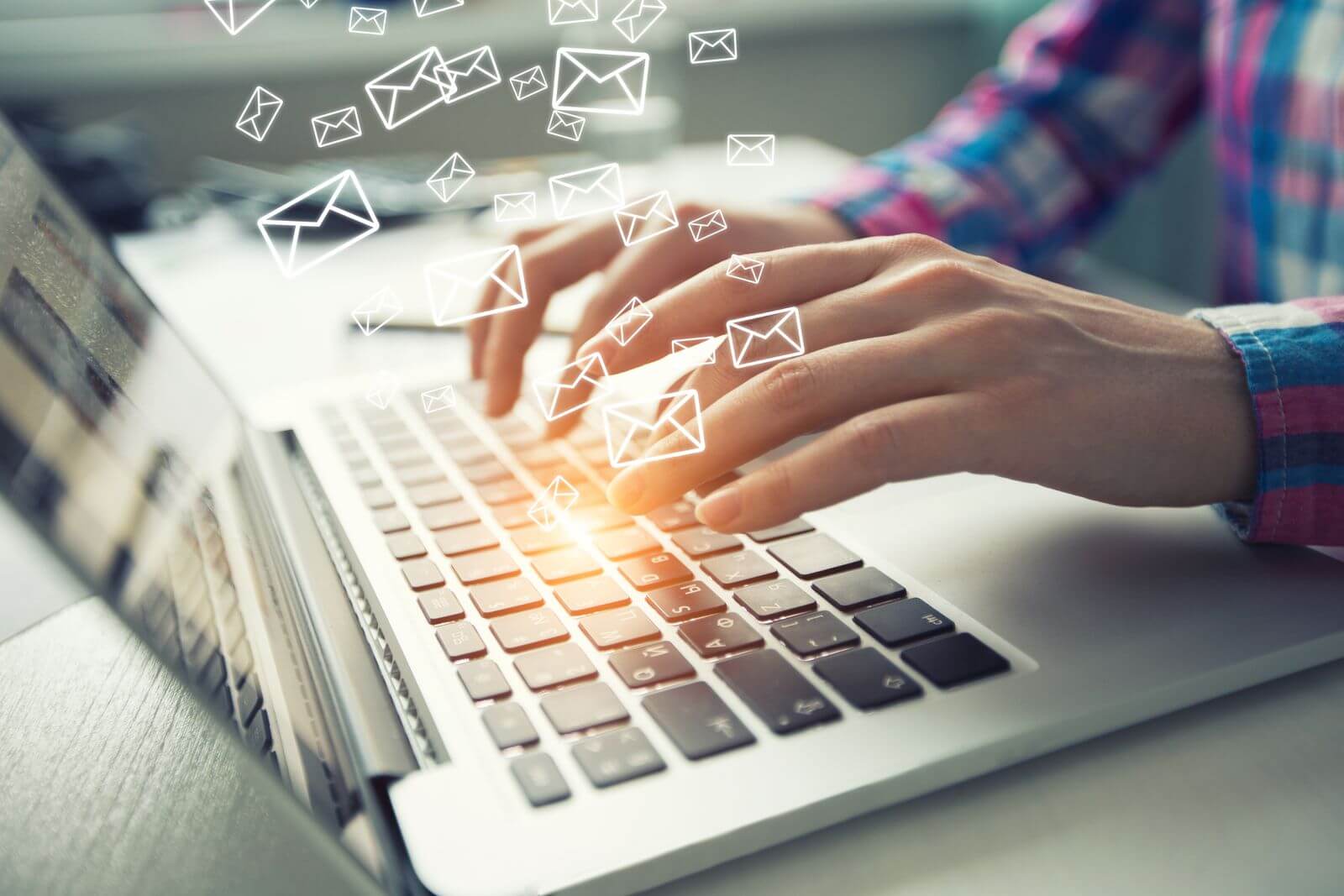 Man sending emails on laptop