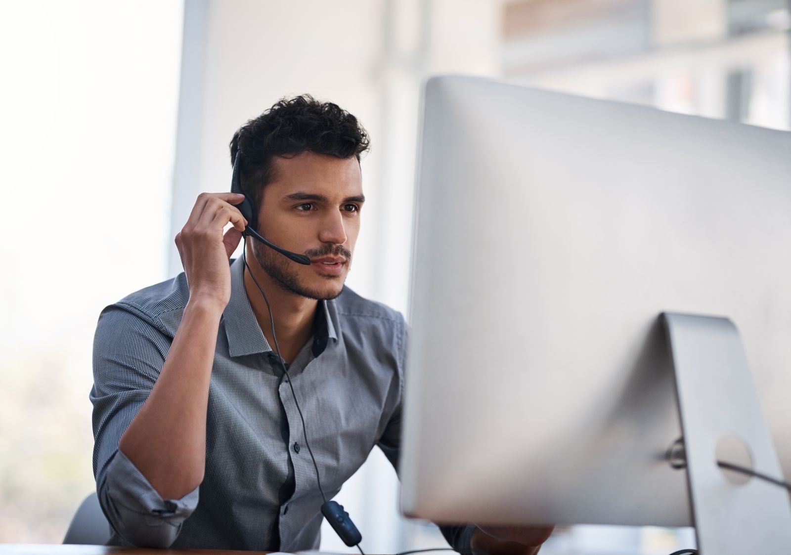 Employee working at computer with headset