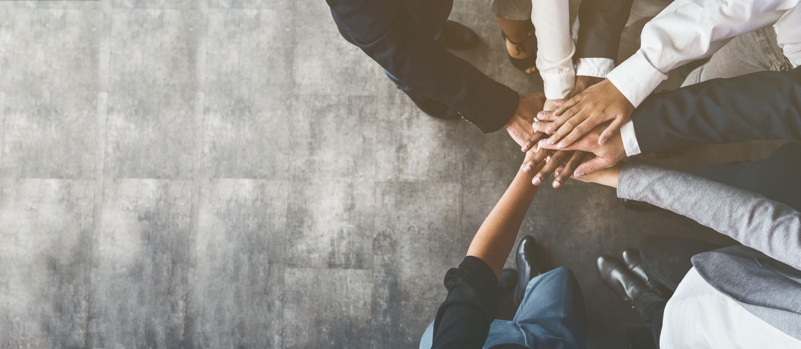 Coworkers putting their hands together in unison