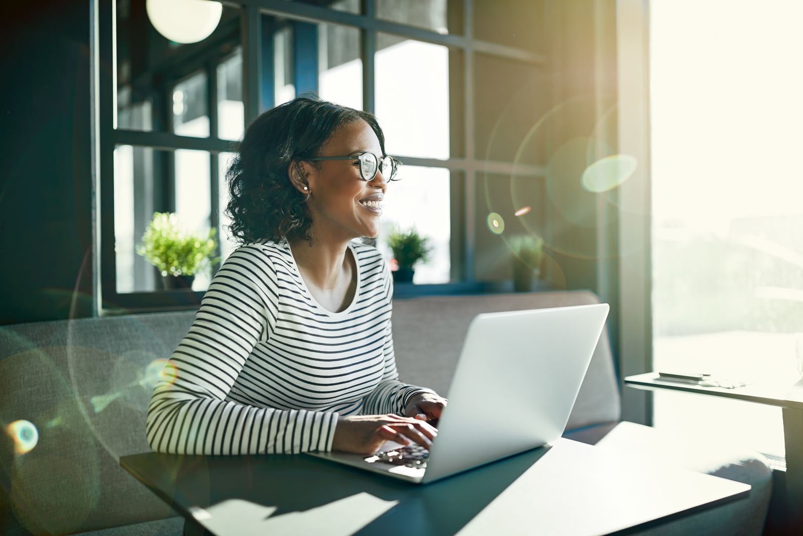 Woman sitting in sun while she works from home