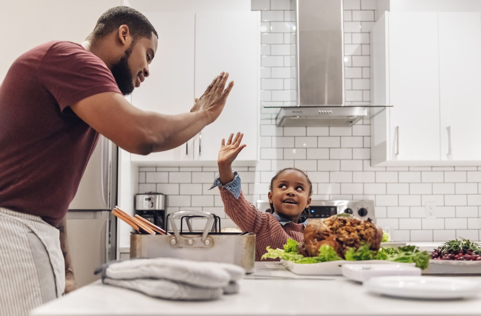 Dad cooking Thanksgiving dinner with his daughter