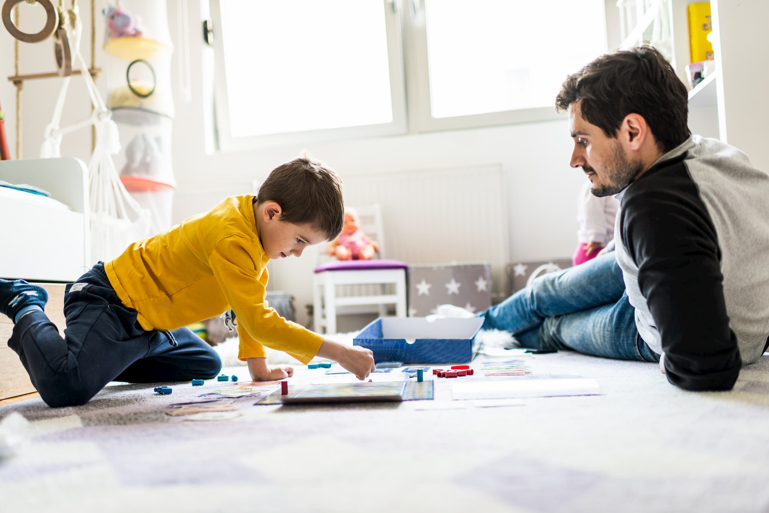 Dad playing with his son in a bright room