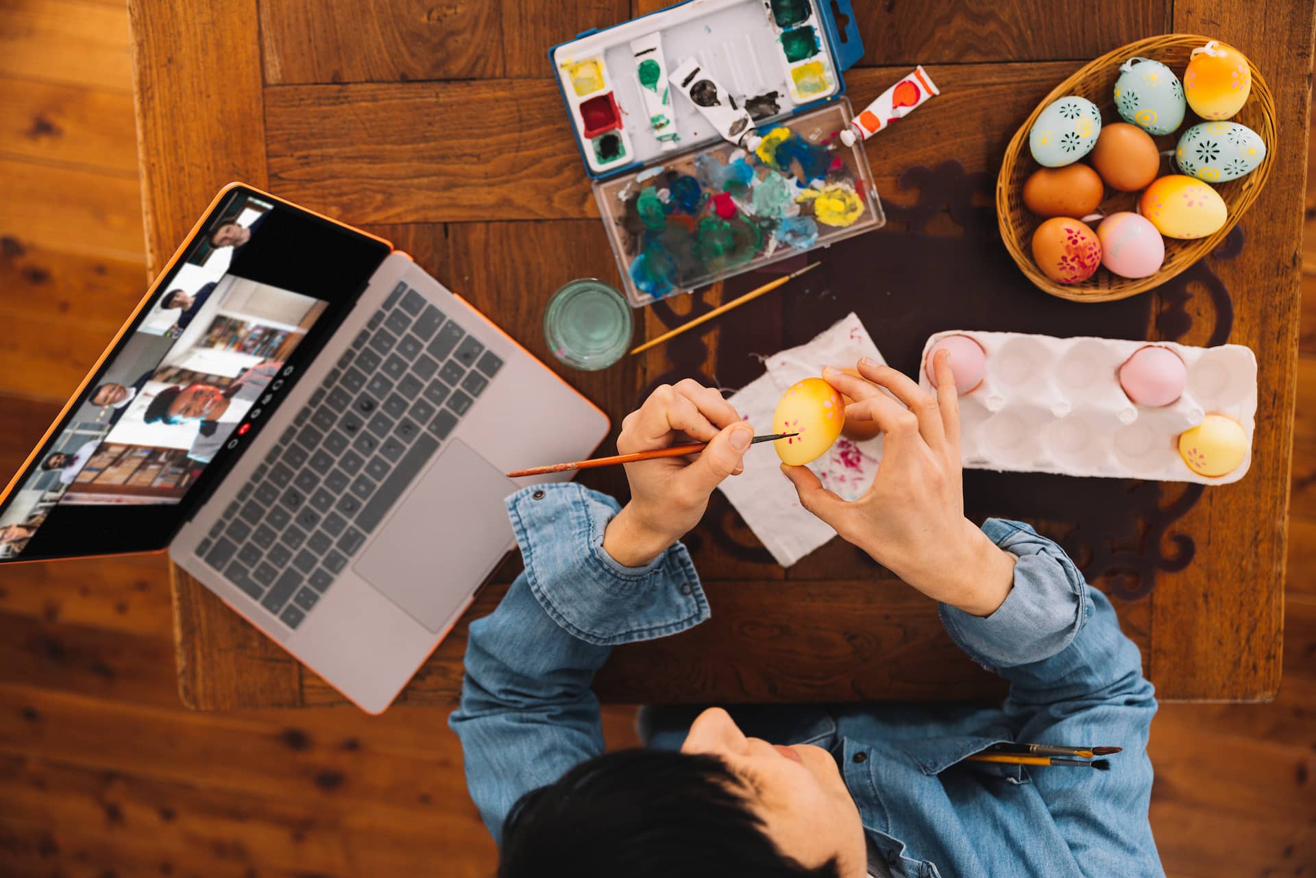 woman painting easter eggs with video chat