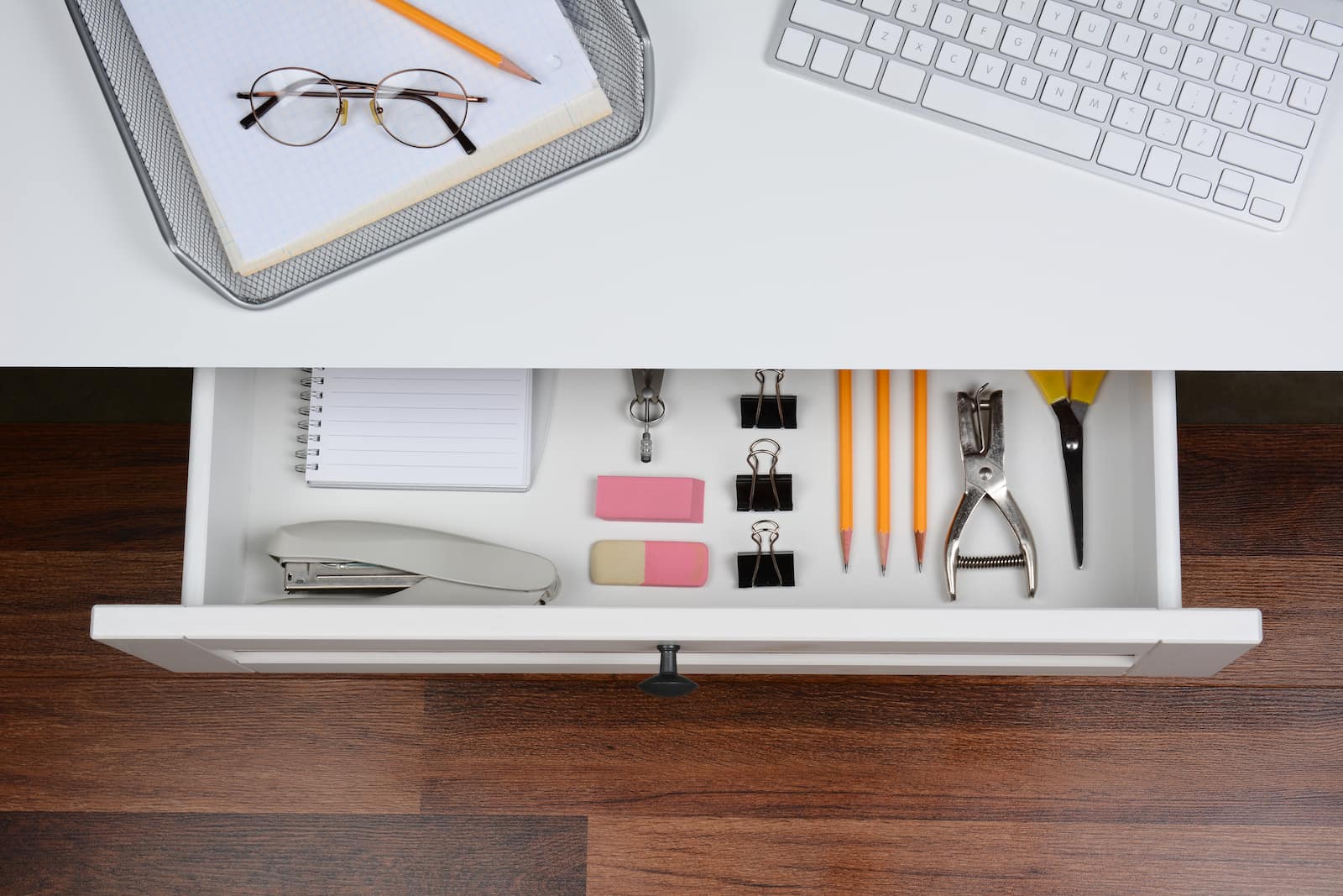 drawer with office supplies stapler, pencils, laptop