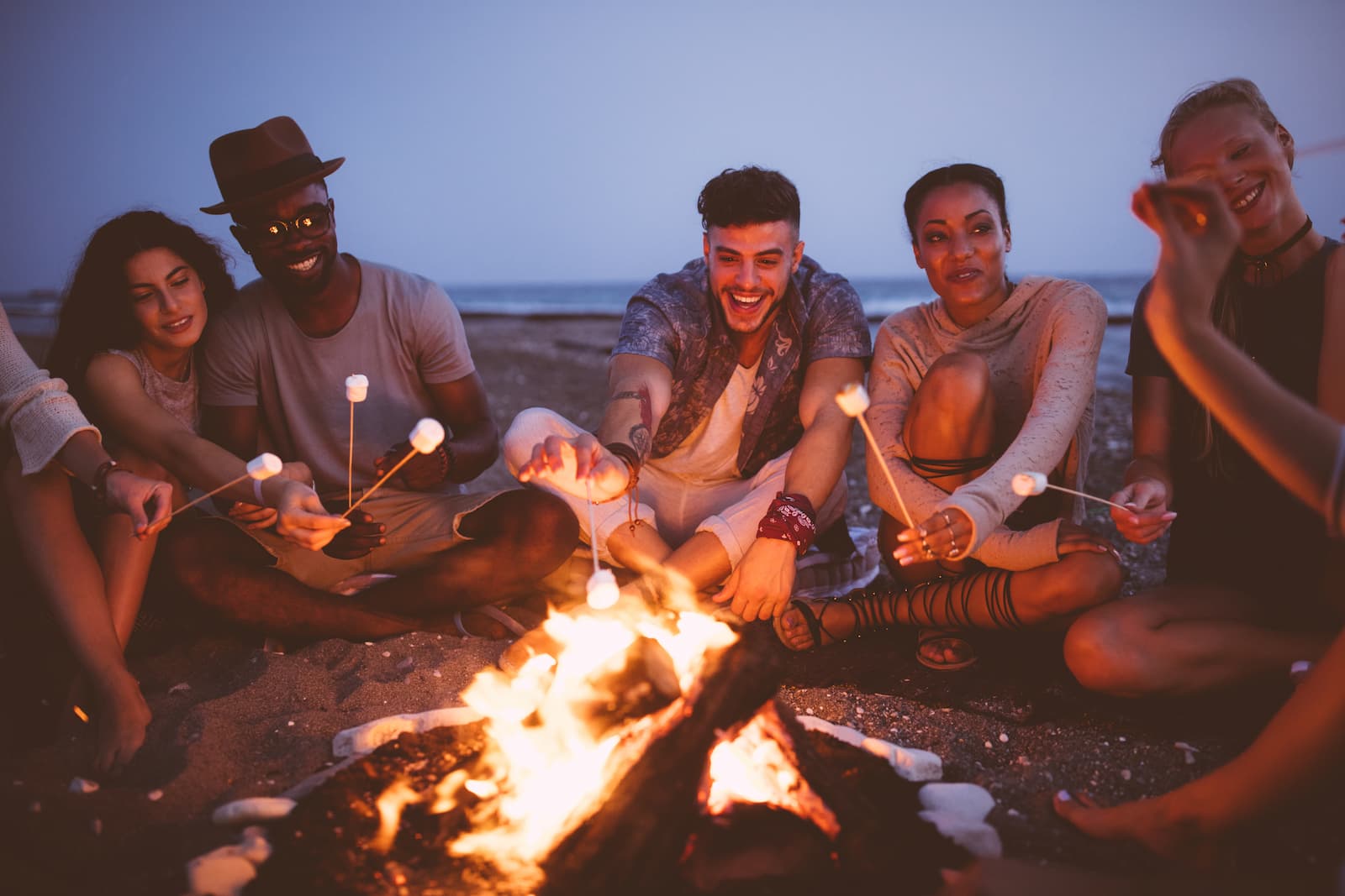 friends at a bonfire roasting marshmallows