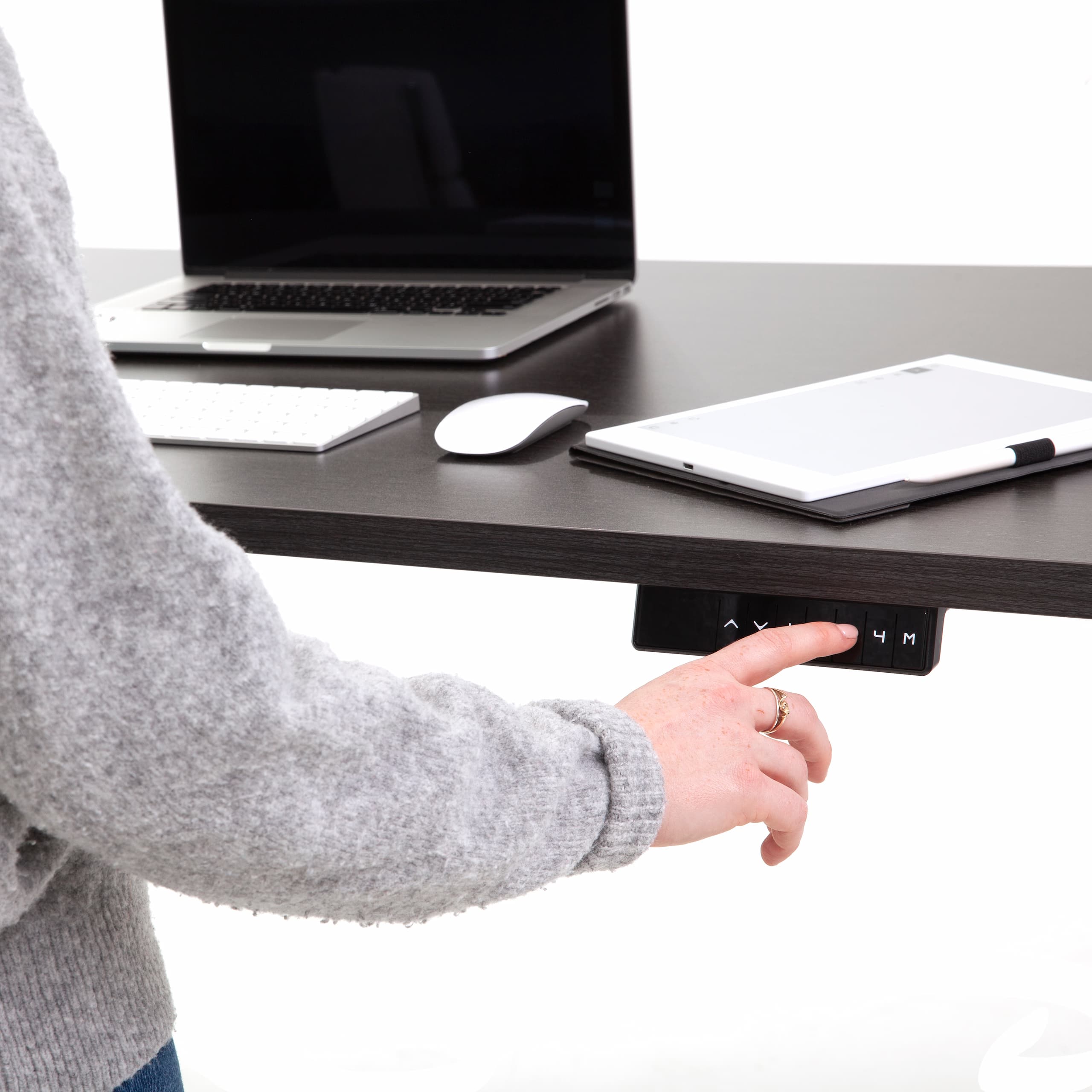 Woman ajdusting her standing desk with the touch of a button