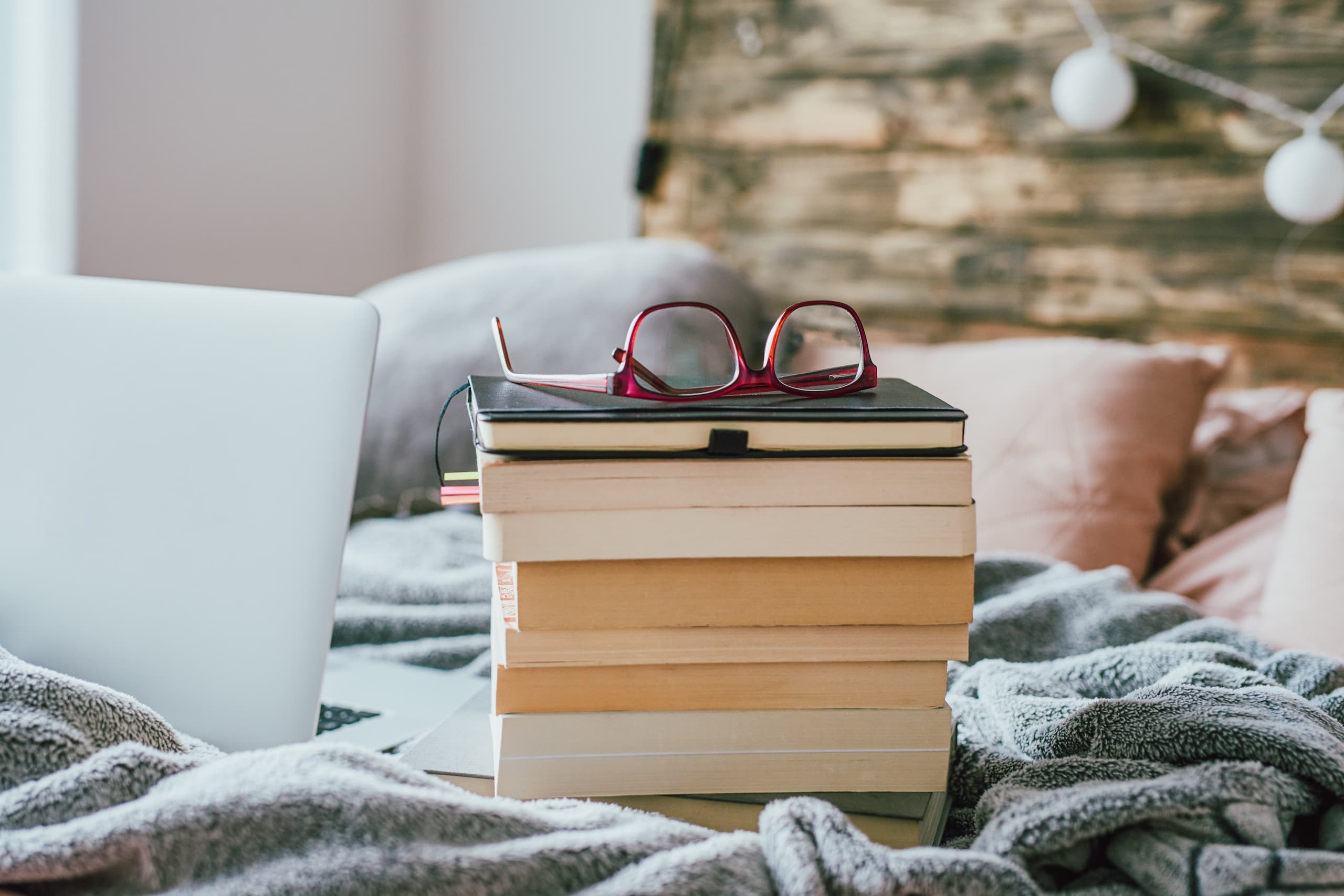 Pile of books on a comfy bed