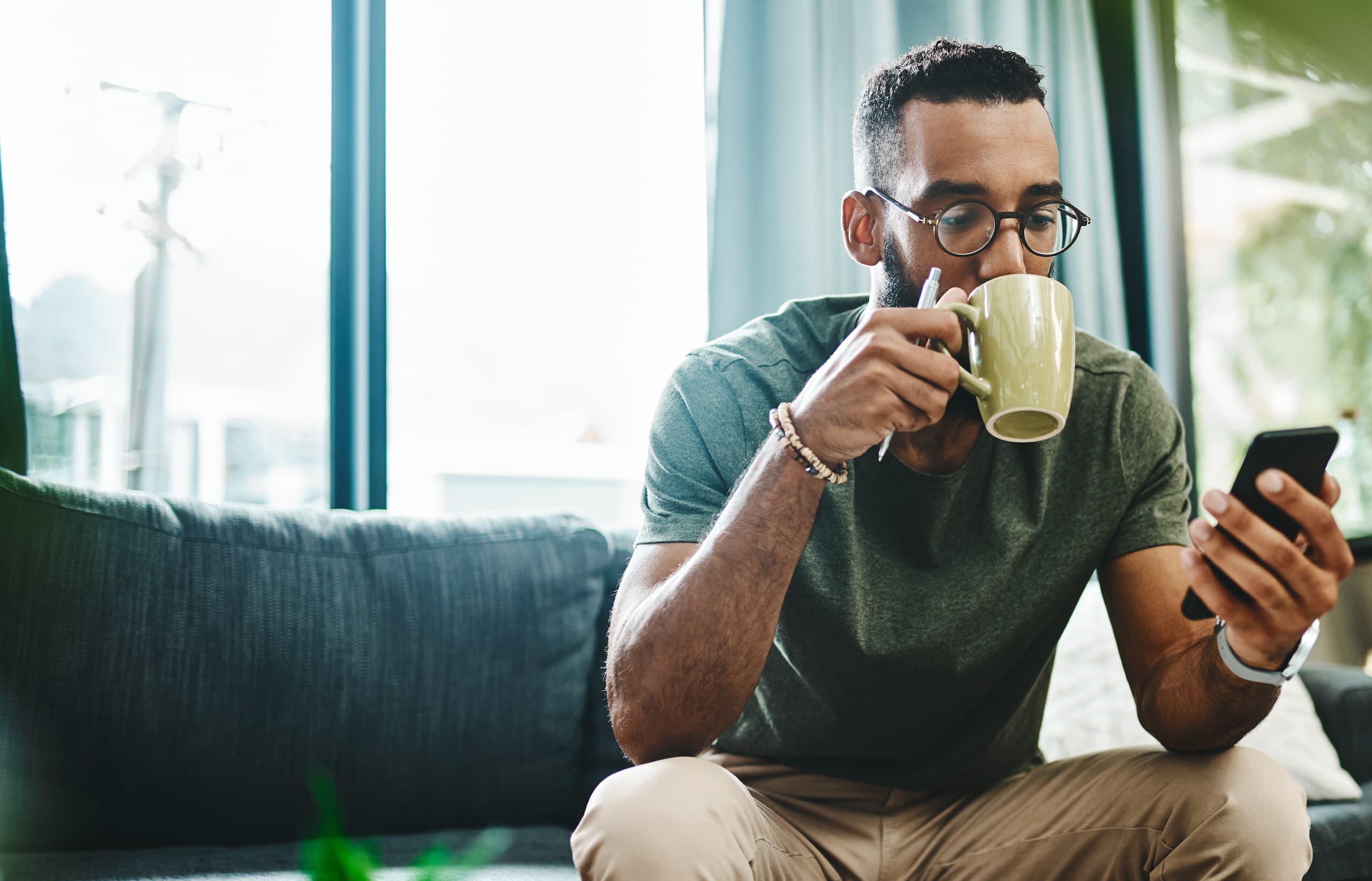 Man drinking a cup of coffee on the couch