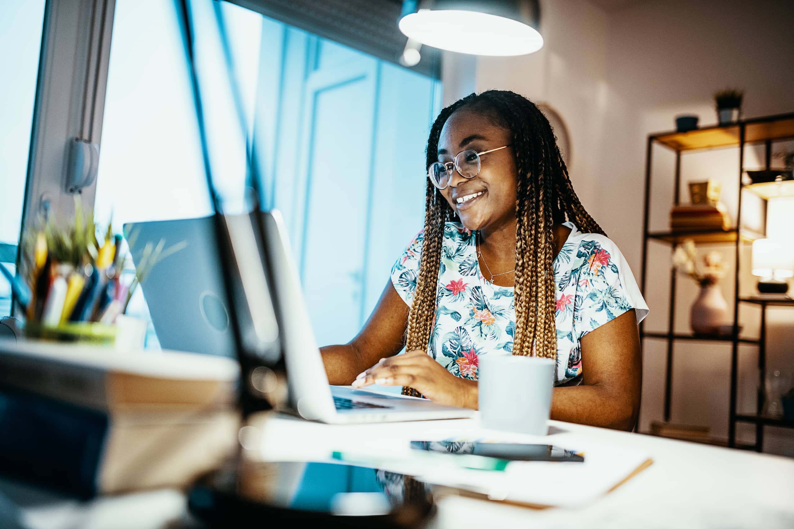 Young woman smiling while studying on her laptop